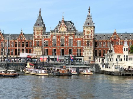 Téléchargez les photos : Amsterdam, Pays-Bas. 24 juin 2023. Gare centrale d'Amsterdams et les bateaux du canal sur la Prins Hendrikkade. Photo de haute qualité - en image libre de droit