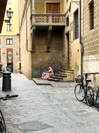 Téléchargez les photos : Florence, Utaly. 16 septembre 2023. Deux femmes suppliant et assises sur un petit escalier à Florence. Photo de haute qualité - en image libre de droit