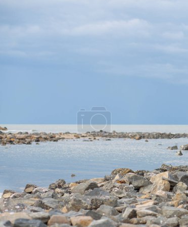 Photo for Lots of rocks by the sea, clear sky sea background. - Royalty Free Image