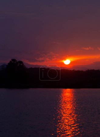 Photo for The sun was about to set in red. In front of the lake was a lake of sunlight reflecting the water. Blurred image, difficult to describe. - Royalty Free Image