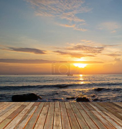 Photo for Beautiful wooden floor and background silhouette of sea and sky at sunset over sea bridge over river or sea at dusk or dusk.Rocks on the beach with sea and mountains in the background at sunset. - Royalty Free Image