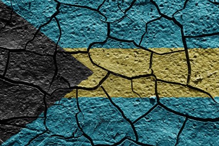 Téléchargez les photos : Bahamas flag on a mud texture of dry crack on the ground - en image libre de droit