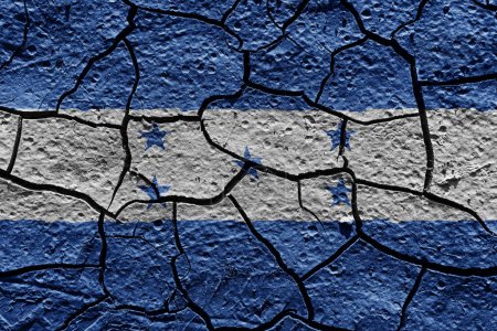 Téléchargez les photos : Honduras flag on a mud texture of dry crack on the ground - en image libre de droit