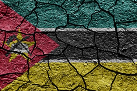 Téléchargez les photos : Mozambique flag on a mud texture of dry crack on the ground - en image libre de droit