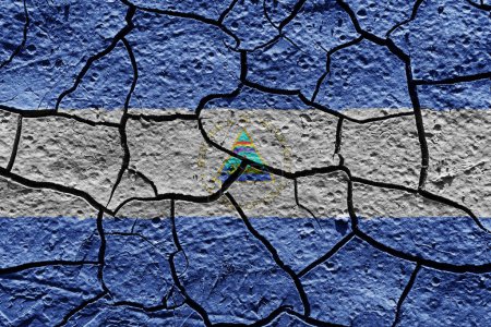 Téléchargez les photos : Nicaragua flag on a mud texture of dry crack on the ground - en image libre de droit