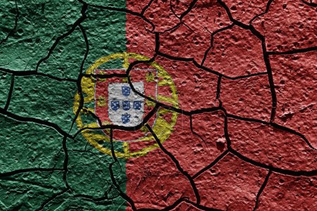 Téléchargez les photos : Portugal flag on a mud texture of dry crack on the ground - en image libre de droit