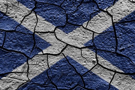 Téléchargez les photos : Scotland flag on a mud texture of dry crack on the ground - en image libre de droit