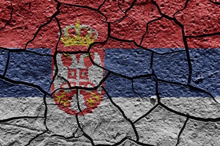 Téléchargez les photos : Serbia flag on a mud texture of dry crack on the ground - en image libre de droit