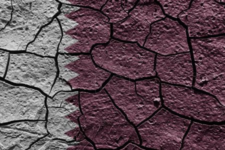 Téléchargez les photos : Qatar flag on a mud texture of dry crack on the ground - en image libre de droit