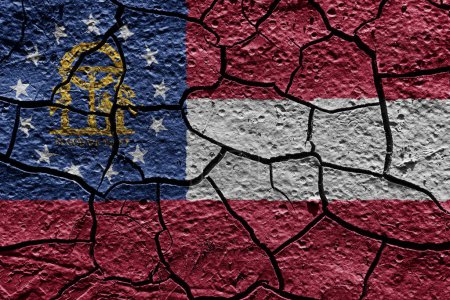 Téléchargez les photos : Georgia state flag of United States on a mud texture of dry crack on the ground - en image libre de droit