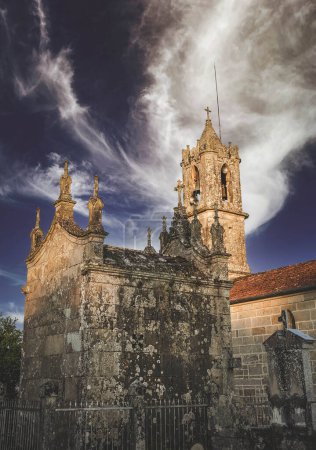 Foto de Campanario de una iglesia del pueblo visto desde una construcción anexa con columnas - Imagen libre de derechos