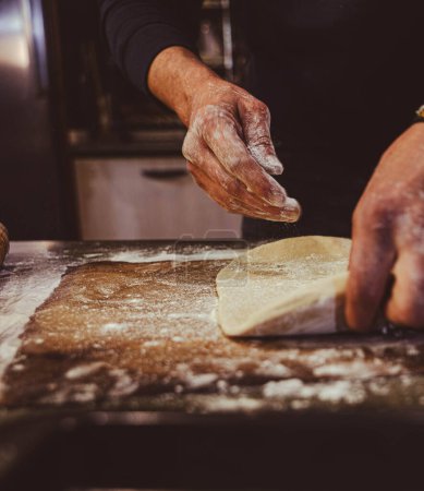 Foto de Manipular la masa para hacer una empanada con todos en una mesa de cocina - Imagen libre de derechos