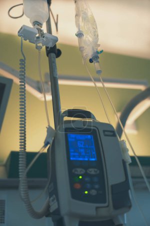 Containers of intravenous serum inoculated by a machine in a hospital room