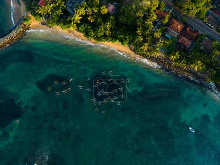 Téléchargez les photos : Bateaux de pêche en canot traditionnels colorés dispersés sur les eaux tropicales de la mer bleue, photo aérienne de drone de divers navires marins. Aérien de bateaux renversés. Oruwas au Sri Lanka. Vue aérienne. - en image libre de droit