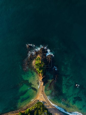 Photo for Top down drone shot of picturesque coastal landscape, with road cutting between serene sea and green cliffside, perfect for natural backgrounds and geographical explorations. Parrot Rock, Sri Lanka. - Royalty Free Image