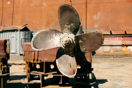 Photo for Vintage marine propeller on dry dock background, evoking nautical engineering history and oceanic vessel maintenance. - Royalty Free Image