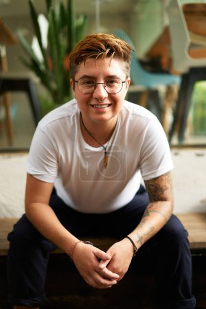 Inclusive workplace, corporate diversity. Confident transgender man in casual clothes smiles at camera, modern office environment. Professional portrait, gender identity pride, LGBTQ friendly.
