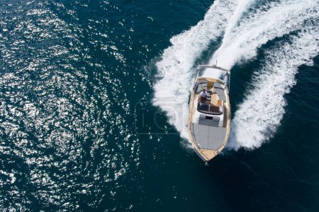 Drone vista superior de un pequeño barco de lujo navegando a alta velocidad en el mar Mediterráneo