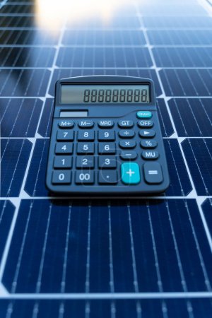 Téléchargez les photos : Image d'une calculatrice sur un panneau solaire représentant le concept d "économie d" énergie avec les énergies renouvelables - en image libre de droit