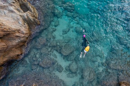 Landschaft aus der Luft von der Drohne eines Schwimmers im offenen Wasser mit Neoprenanzug und Boje