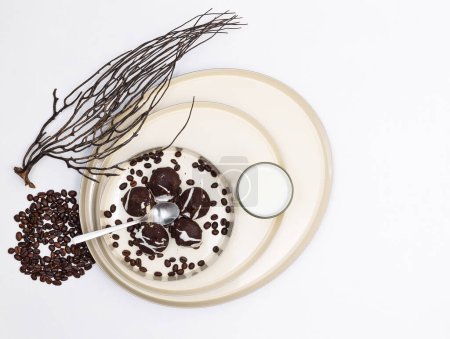 Téléchargez les photos : Biscuits aux pépites de chocolat et grains de café noirs sur un plat sur fond blanc, vue de dessus, pose plate, horizontalement, copyspase sur la droite - en image libre de droit