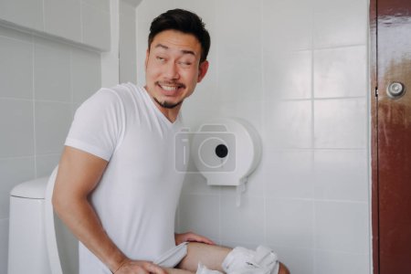 Photo for Funny face asian man pushing poop in the toilet as he has constipation. - Royalty Free Image