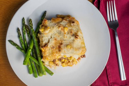 Photo for Freshly baked shepards pie served withs auteed  asparagus, - Royalty Free Image