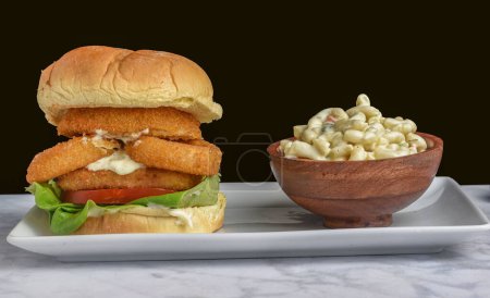 Photo for Fish fillet sandwich  top with  onion rings  served with macaroni salad, - Royalty Free Image