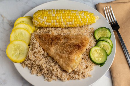 Photo for Baked haddock   resting on  brown rice   served with  corn and dsquash, - Royalty Free Image