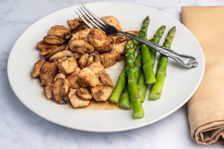 season chicken bites  top with mushrooms and served with  asparagus