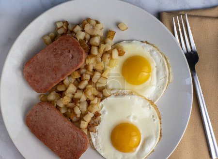 Photo for Breakfast plate of fried eggs  served with  fried spam  and hash browns - Royalty Free Image