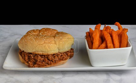 Photo for Sloppy joe on a bulkie roll served with sweet potato fries, - Royalty Free Image