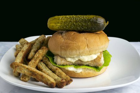 Photo for Baked haddock sandwich  served with broccoli  fries and pickle - Royalty Free Image