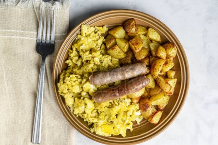 Photo for Scramble eggs served with home fries and top with breakfast sausage, - Royalty Free Image