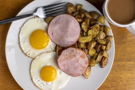 Téléchargez les photos : Bacon canadien servi avec œufs frits, frites maison et café. - en image libre de droit