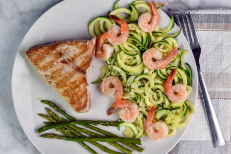 Photo for Tuna steak  served with zucchini noodle top with shimp and asparagus - Royalty Free Image