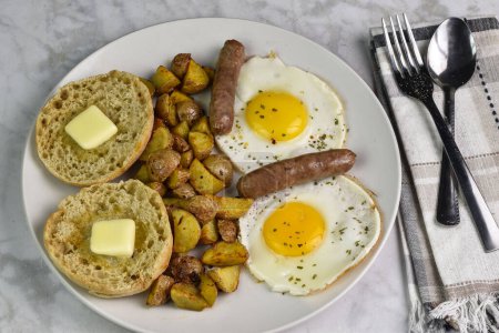 two fried egg top with parsley  served with breakfast links and home fries