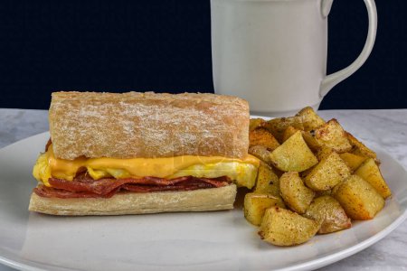 scramble egg and cheese  with  bacon  on ciabatta bread  served with home fries