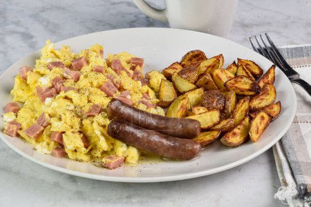 scramble eggs mixed with spam and  served with sausages and a side of home fries