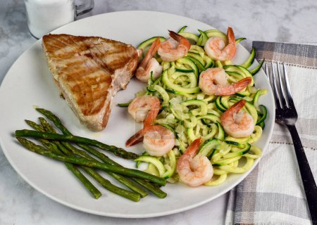 Photo for Tuna steak  served with zucchini noodle top with shimp and asparagus - Royalty Free Image