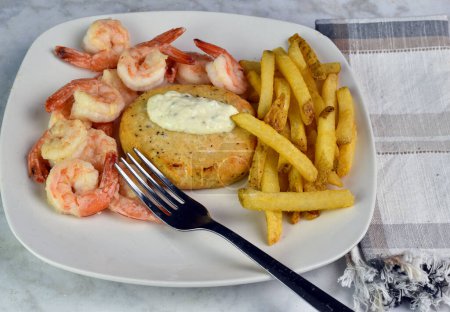 salmon burger  top with tarter sauce served with shrimp anfd french fries