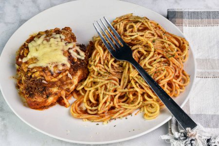 chicken parmesan  served with spaghetti top with parsley