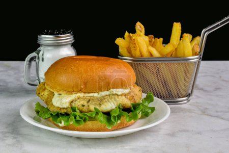 cod fillet sandwich  top with tarter sauce and a side of fries