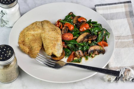baked haddock served with sauteed spinach, tomatoes and mushrooms,