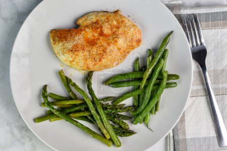 baked seasoned chicken breast served with sauteed green beans and asparagus,