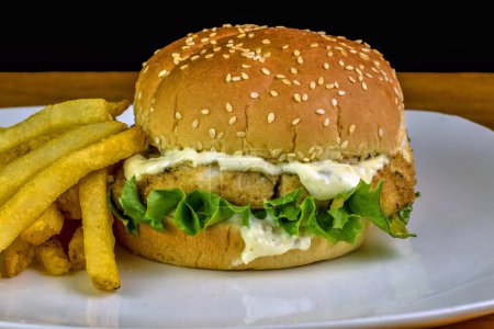 haddock fillet with  lettuce and tarter sauce on a sesame bun served with  fries