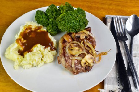 boneless steak top with onions and mushrooms served with mash potatoes