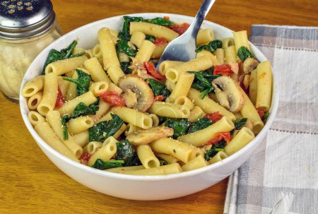 ziti served with sauteed spinach , tomatoes and mushrooms