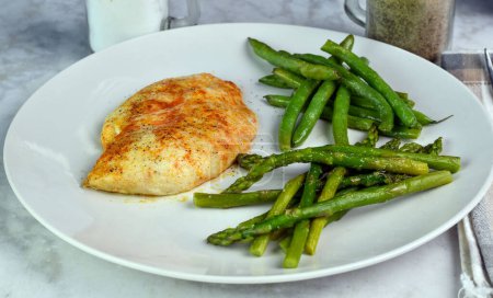 seasoned chicken breast served with sauteed green beans and asparagus,
