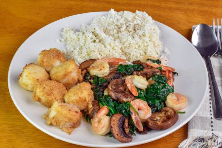 scallops with rice  served with sauteed shimp, spinach and  mushrooms